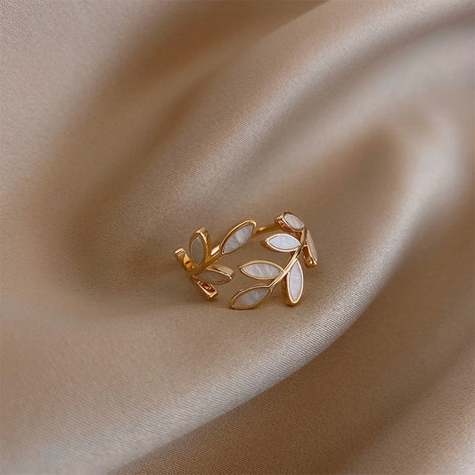Aanpasbare gouden ring met bladmotief en witte opaal