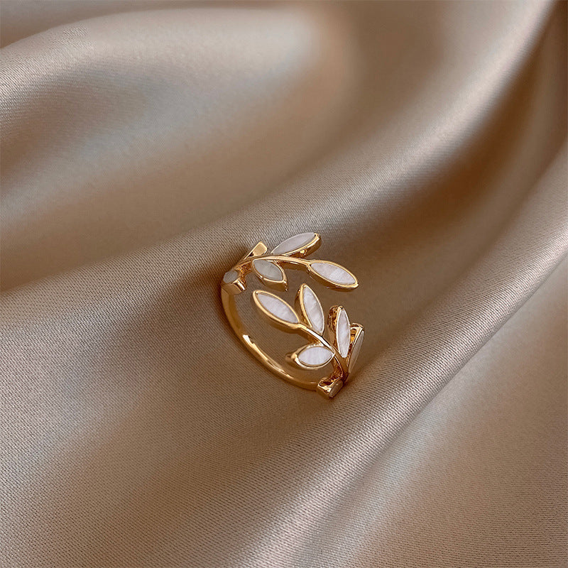 Aanpasbare gouden ring met bladmotief en witte opaal
